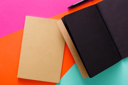Modern creative work space. Stylish open notepad with black pages and craft envelope on abstract...