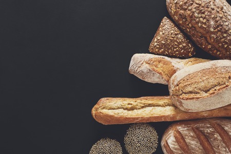 Bakery background, bread assortment isolated on black. Top view with copy spaceの写真素材