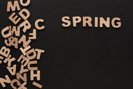 Word Spring with heap of wooden letters on black background. Season learning, education conceptの写真素材