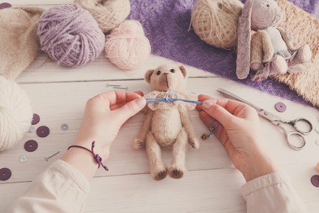 Process of making vintage toy, top view. Artisan pov, needlewoman hands sewing handmade teddy bear, home workshopの写真素材