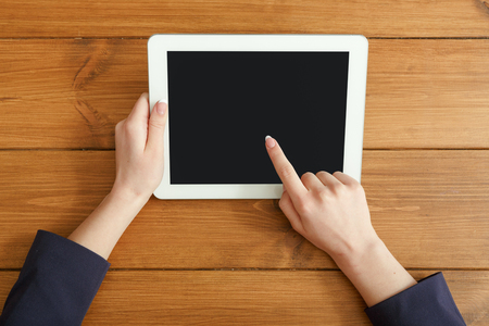 Female using digital tablet. Freelancer working with portable computer, copy space on display, top view, close upの写真素材