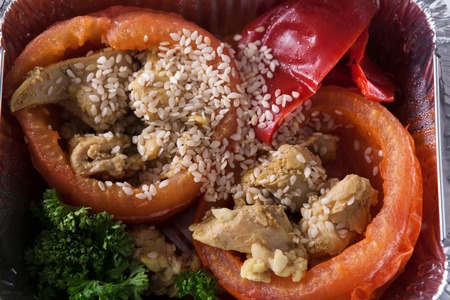 Healthy lunch in foil container. Healthy food take away and delivery. Bell pepper stuffed with chicken, broccoli, sesame, closeupの写真素材