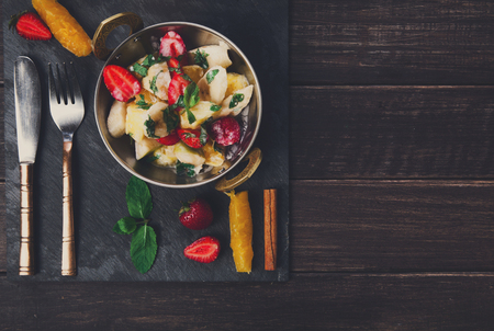 Healthy restaurant food. Indian salad with fruits served in copper bowl on wooden table, top viewの写真素材