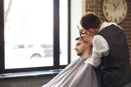 Men barbershop. Making modern hairstyle in male hair salonの写真素材