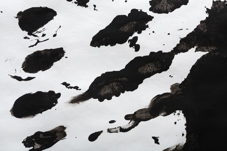 Abstract background with black watercolor handpainted spots on white paper. Black and white textured backdropの写真素材