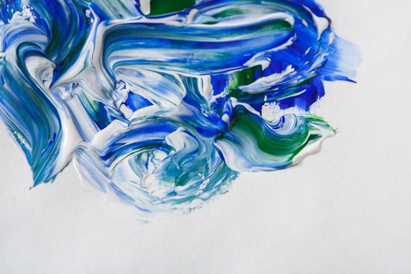 Palette with green and white mixed oil-paints texture on canvas, close-up, abstract background