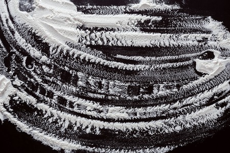 Abstract background with floor on black, sprinkled with copy space. Top view on blackboard or table. Cooking dough or pastry.の写真素材