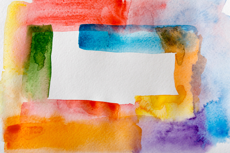 Abstract watercolor strokes painted texture background. Red, violet, yellow, green and blue colors making frame on white paper for copy spaceの写真素材