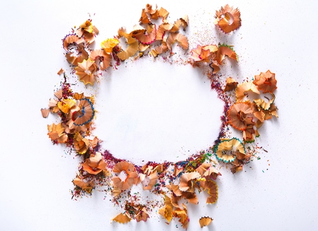 Colored pencil shavings frame, on white background, top view, flat lay, copy spaceの写真素材