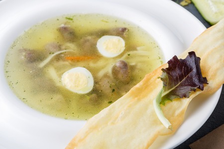 Healthy restaurant food background. Noodle soup with meatballs, quail eggs and flat bread closeup on...