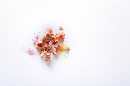 Wooden colored pencil sharpening shavings pile on white isolated background, top view, flat lay, copy spaceの写真素材
