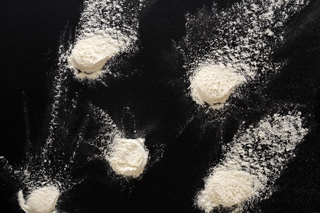 White flour splash spot on black background. Top view on blackboard. Baking concept, cooking dough or pastry.の写真素材