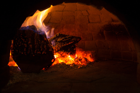 Fire burning in small black iron stove in steak-house restaurant, closeupの写真素材