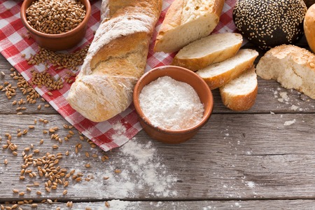 Fresh white bread background, top view with copy space. Homemade baguette loaves on rustic woodの写真素材