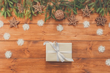 Christmas decoration, gift box and garland frame concept background, top view on wood table surface. Christmas ornaments and presents border with snowflakes and starsの写真素材