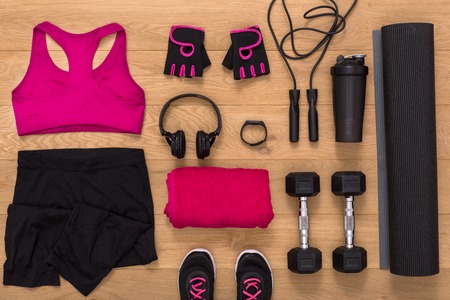 Female sport clothing and equipment top view. Set of fitness outfit and accessories for women on wood, active lifestyle, body care conceptの写真素材