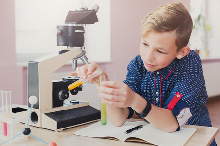 Stem education. Teenage boy doing chemical research with reagents in laboratory, closeup. Early development conceptの写真素材