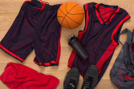 Basketball player outfit top view. Professional uniform, ball and sneakers on parquet floorの写真素材
