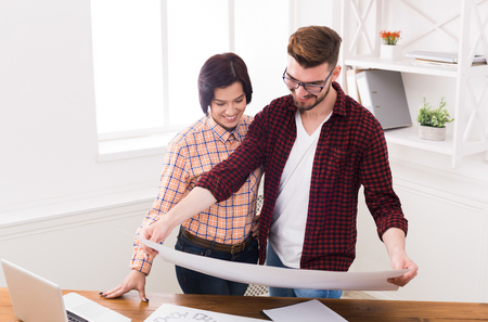 Two smiling architects discussing building plan. Designers team working with new project in office, copy spaceの写真素材