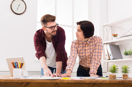 Serious focused professional designers team working on project, discussing functional space creation, decoration ideas, choosing color schemeの写真素材