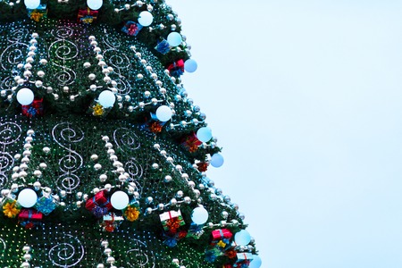 Decorated christmas tree outdoors, sparkling garland and lights, holiday background with copy spaceの写真素材