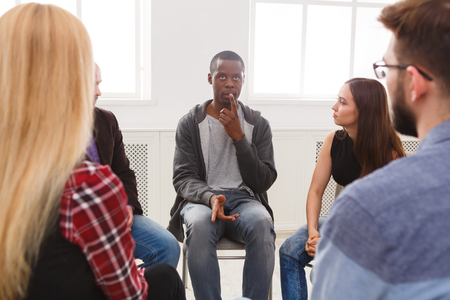 Meeting of support group. African-american man talking about his life, telling his problems and issues. Mental health, psychotherapy conceptの写真素材