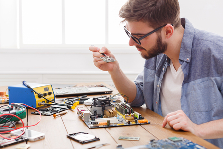 Technician upgrade of computer close up. Repairman renovate microchip component in motherboard....