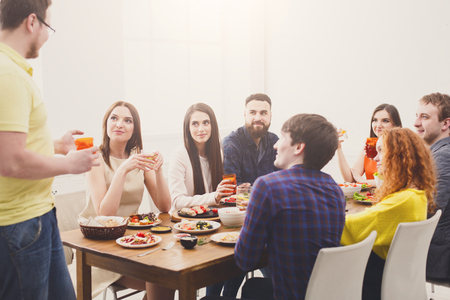 Saying toast at party dinner with friends. Happy people drink lemonadeの写真素材