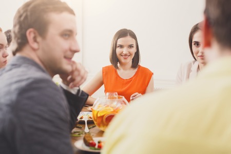 Friends meeting. Group of happy people drink wine at party dinner table in cafe, restaurant. Young company celebrate with alcohol and food at wooden table indoors.の写真素材