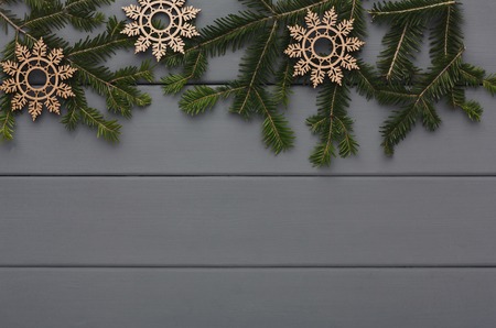Christmas background with copy space, top view on pine tree twigs and wooden ornate snowflakes frame...