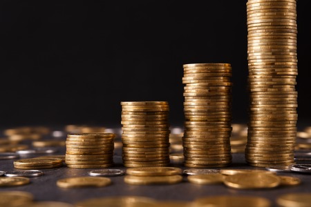 Increasing columns of gold coins on table, black background, copy space. Financial success, cryptocurrency mining, profit conceptの写真素材