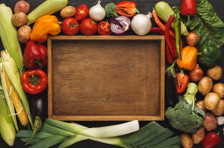 Fresh organic vegetables and wooden box with copy space background. Healthy natural food. Tomato, leek, carrot, pepper, potato and other cooking ingredients top viewの写真素材
