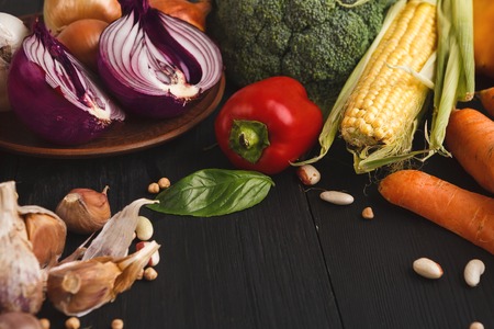 Fresh organic vegetables on wood background. Bell pepper, corn, garlic, onion. Healthy natural food on rustic wooden table with copy space.の写真素材
