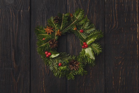 Christmas background with traditional wreath. Fir tree branches garland on brown rustic wall with copy space. Preparing for xmas and new year decorations conceptの写真素材