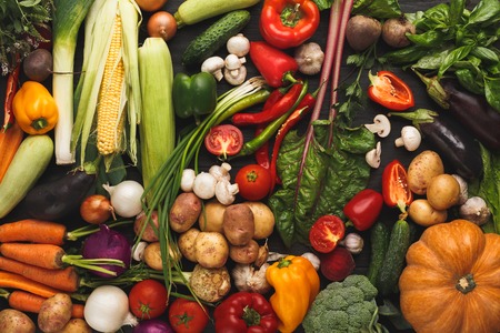 Heap of fresh organic vegetables on wood background. Healthy natural food on rustic wooden table....