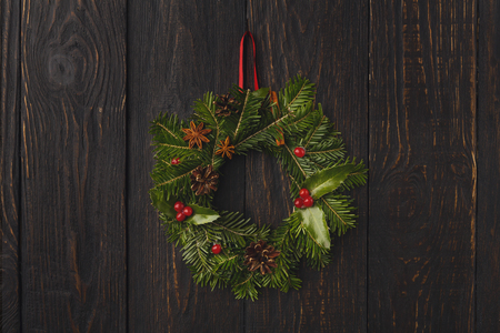 Christmas background with traditional wreath. Fir tree branches garland on brown rustic wall with copy space. Preparing for xmas and new year decorations conceptの写真素材