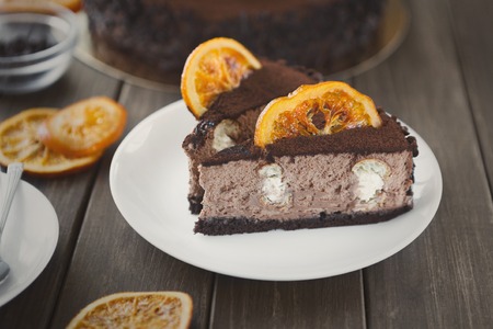 Chocolate cake with cream and profiterole, decorated with candied oranges. Traditional creamy dessert, copy spaceの写真素材