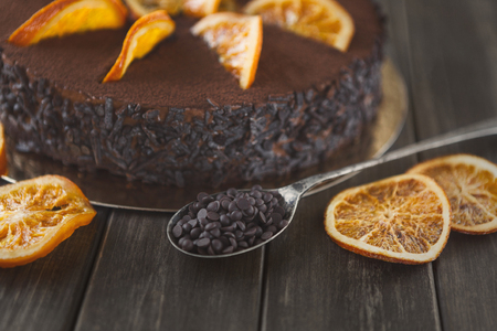 Chocolate cake with cream and profiterole, decorated with candied oranges. Traditional creamy dessert, copy spaceの写真素材