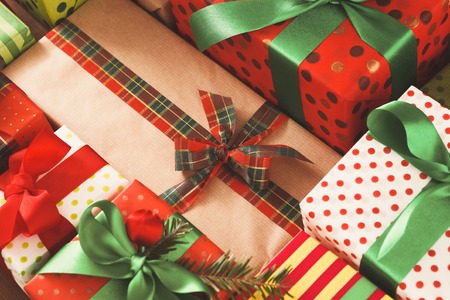 Christmas Gift boxes background closeup. Presents in craft and colored paper decorated with ribbon bows.の写真素材
