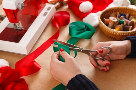 Creative diy craft hobby. Making handmade craft ribbons with scissors. Womans leisure, tools and trinkets for holiday decorations, closeupの写真素材