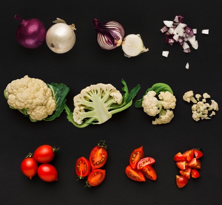 Set of vegetables isolated on black background. Whole and cut cooking ingredients for sald or soup....