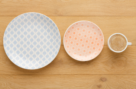 Set of empty vintage plates and black coffee cup, top view on natural wood. Table setting and tableware conceptの写真素材