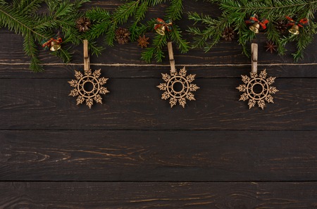 Christmas background with decorations. Wooden snowflakes ornament on twine rope, garland frame, top view with copy space on wooden table. Winter holidays celebration.の写真素材