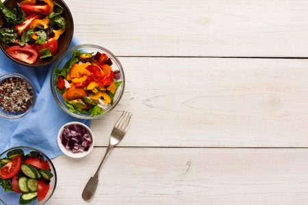 Assorted vegetable salad bowls on white wood top view. Fresh organic snack for vegetarian party food table, copy space. Healthy eating conceptの写真素材