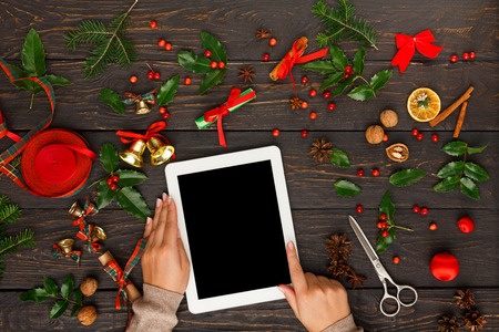 Christmas online shopping. Female buyer makes order at screen of digital tablet with copy space. Woman buys presents for xmas eve. Winter holidays salesの写真素材