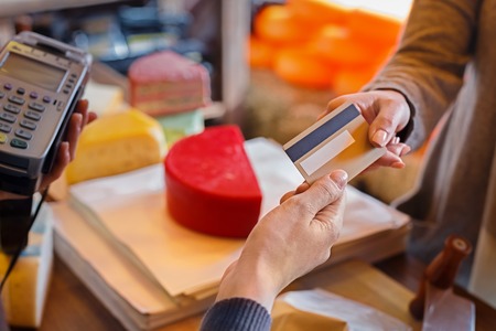Customer paying for order of cheese in grocery shop. Retail, credit card payment service.の写真素材