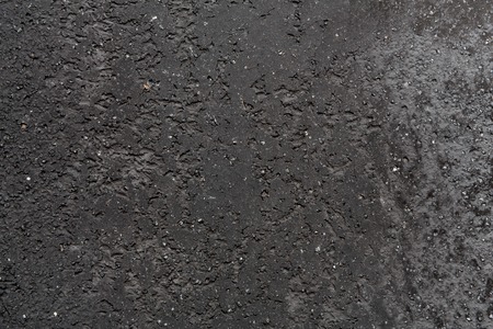 Closeup fragment of grunge black wall of a building. Abstract textured background of concrete with stains, closeup, copy spaceの写真素材