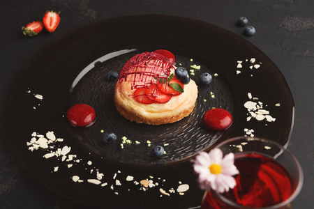 Exquisite restaurant mousse dessert. Chocolate and vanilla souffle on walnut biscuit served on glass plate finely decorated with fresh berries and mint. Exclusive meals and haute cuisine conceptの写真素材
