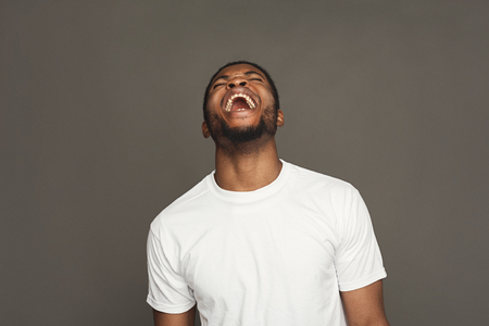 Black man laughing on grey background, studio shot, copy spaceの写真素材