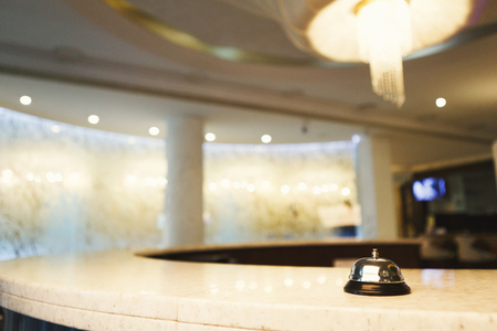 Hotel accommodation call bell on reception desk, contemporary interior, copy spaceの写真素材